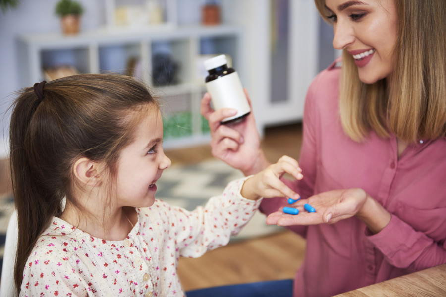Madre dando medicina a hija
