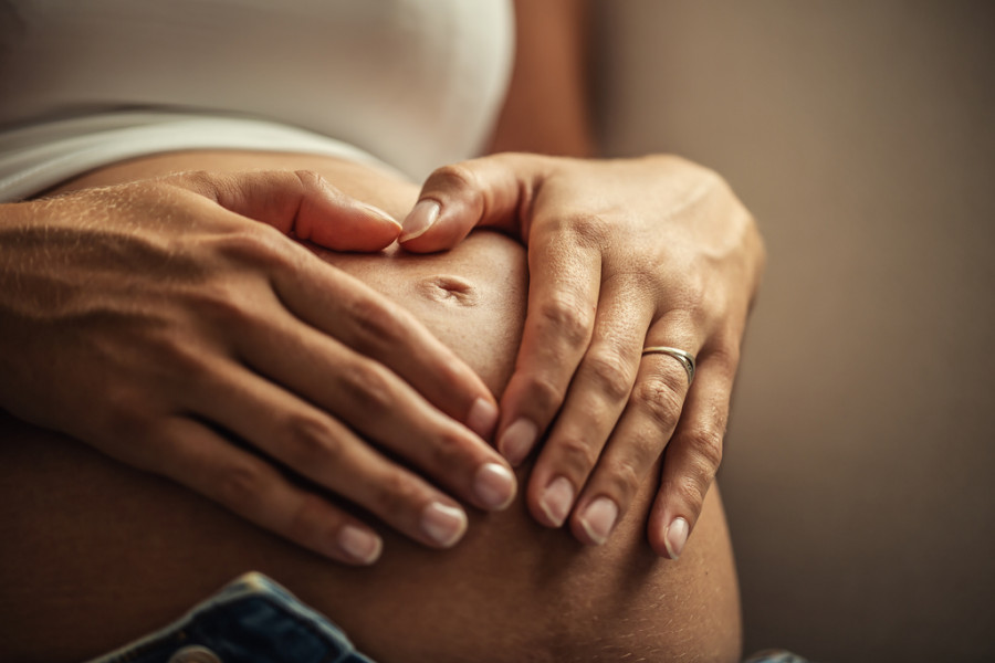 Detail woman s both hands placed her pregnant belly(1)