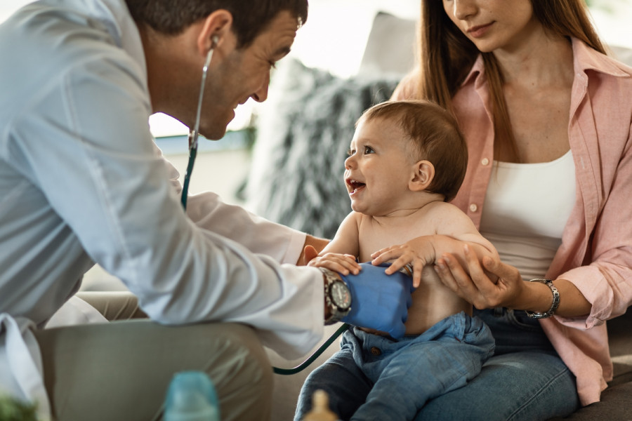 Happy baby boy having fun while doctor is listening his heartbeat with stethoscope(1)(1)